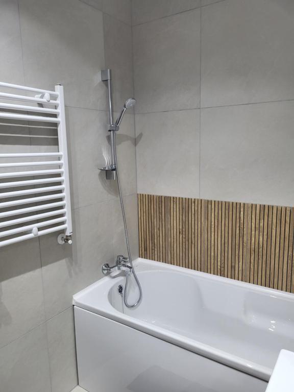 Un baño blanco con bañera y ducha. en Sika Platinum Premium Apartment- private parking, en Arad
