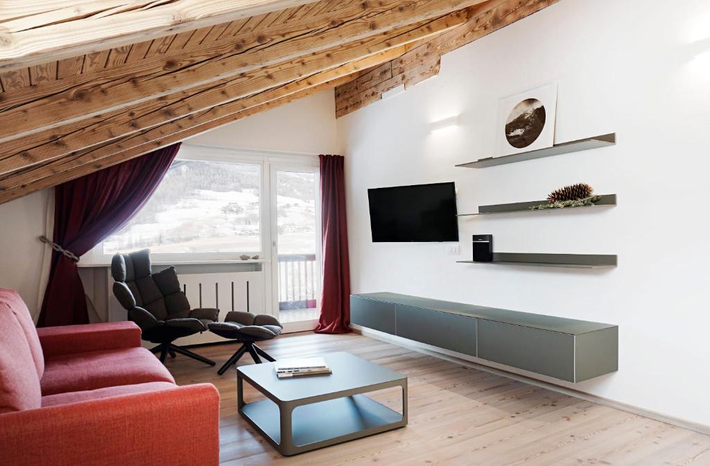 een woonkamer met een bank en een tv aan de muur bij CanguroProperties - Al Mas 1 in Cojana