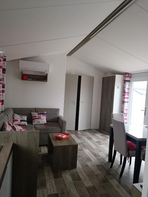 un soggiorno con un divano e un tavolo di mobilhome à la mer a Montreuil-sur-Ille