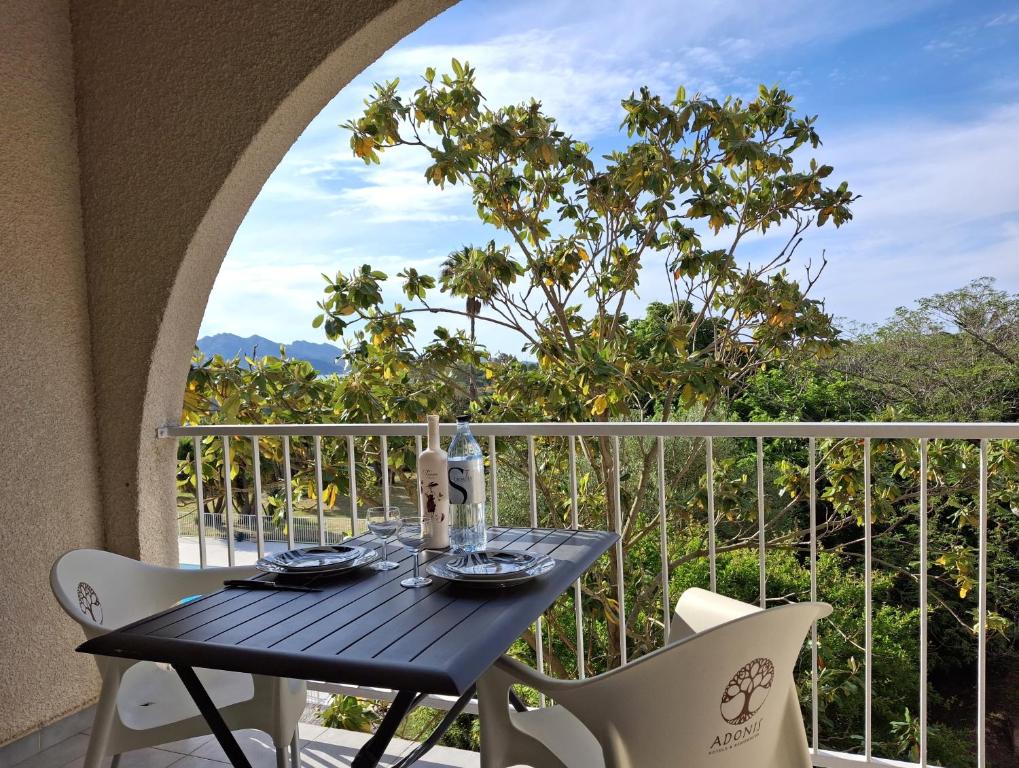 a table and two chairs on a balcony with a view at SAINT-FLORENT Studio 2 pers PISCINE FLO139 in Saint-Florent