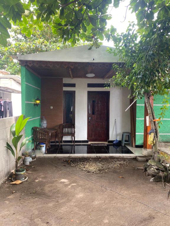 ein kleines Haus mit Grün und Weiß in der Unterkunft Kabin Sahara in Pulau Tidung-kecil