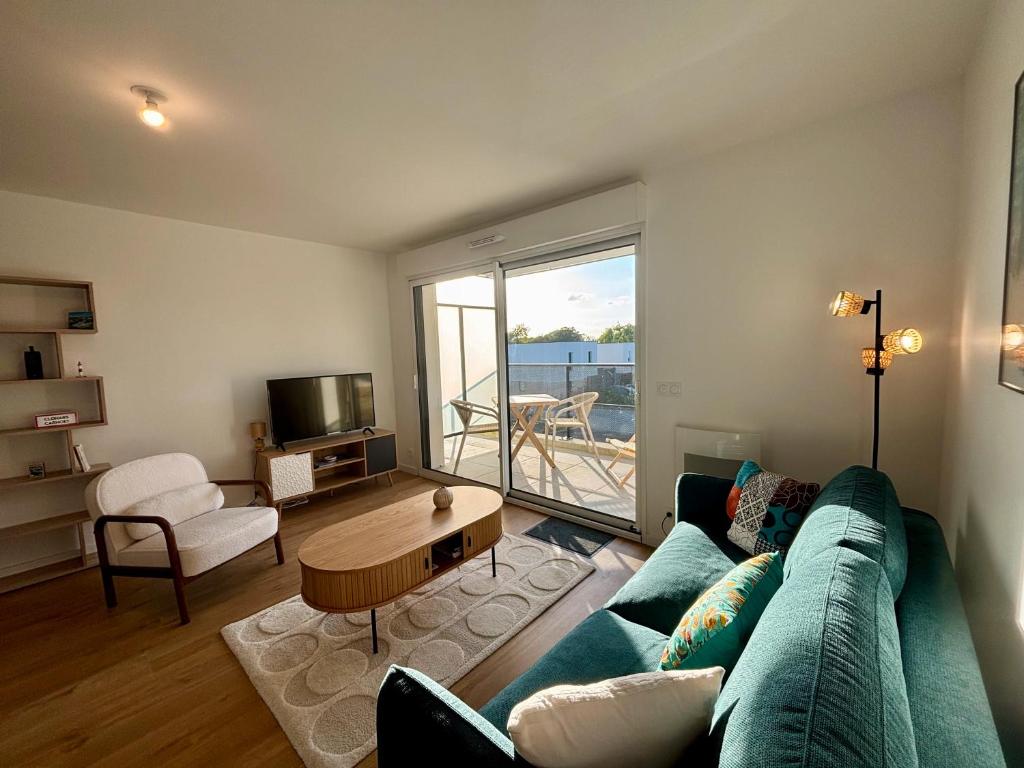 un salon avec un canapé et une table dans l'établissement Le Carnoët, à Clohars-Carnoët