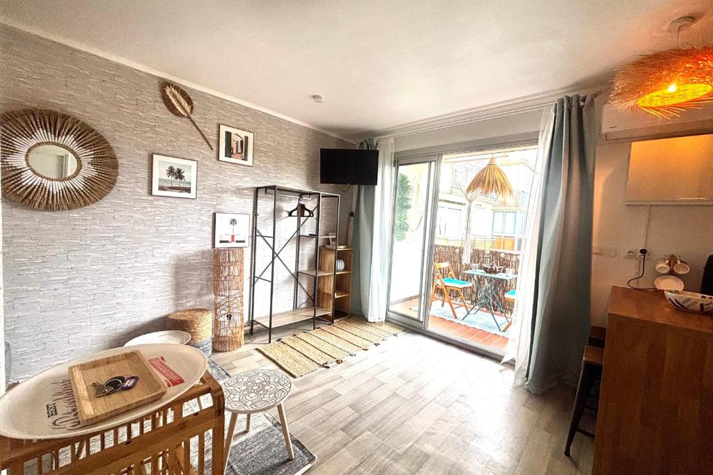 un salon avec une table et une grande fenêtre dans l'établissement La Perle Bleue - Proche plage - Parking - Terrasse, à Argelès-sur-Mer