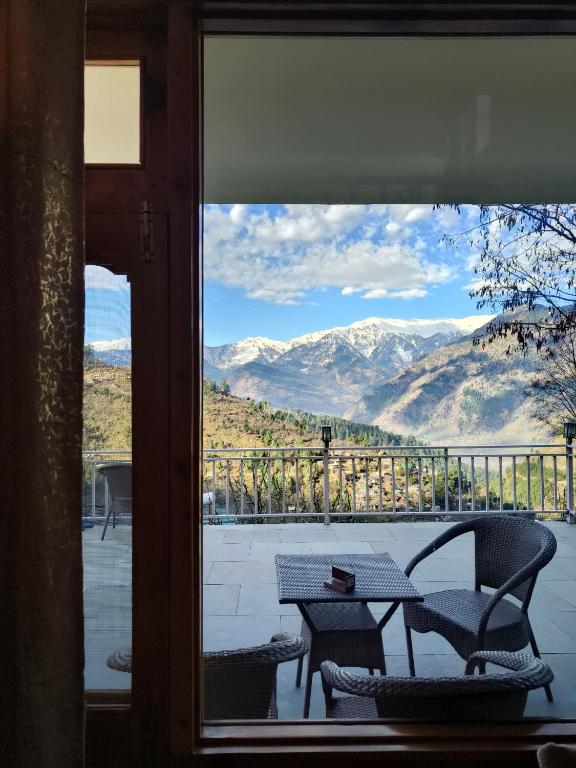 a view of a table and chairs from a window at The Dreamy Chalet in Nagar