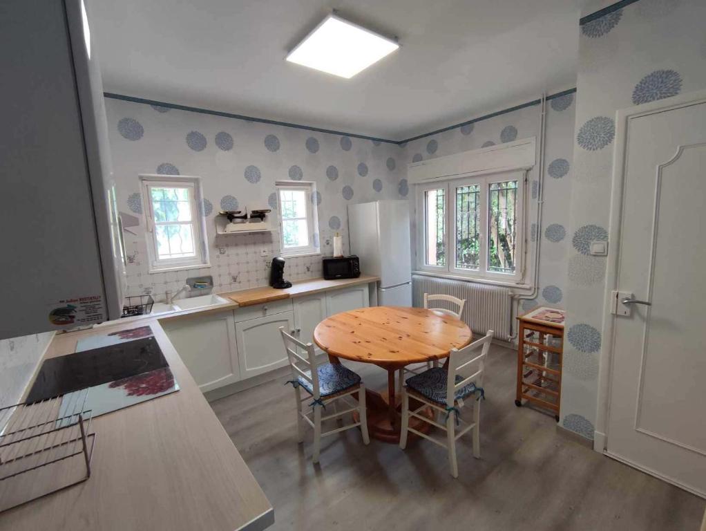 une cuisine avec une table et des chaises dans une pièce dans l'établissement NEW VILLA GLYCINES indépendante 2 chambres jardin clos bien situé, à Carcassonne