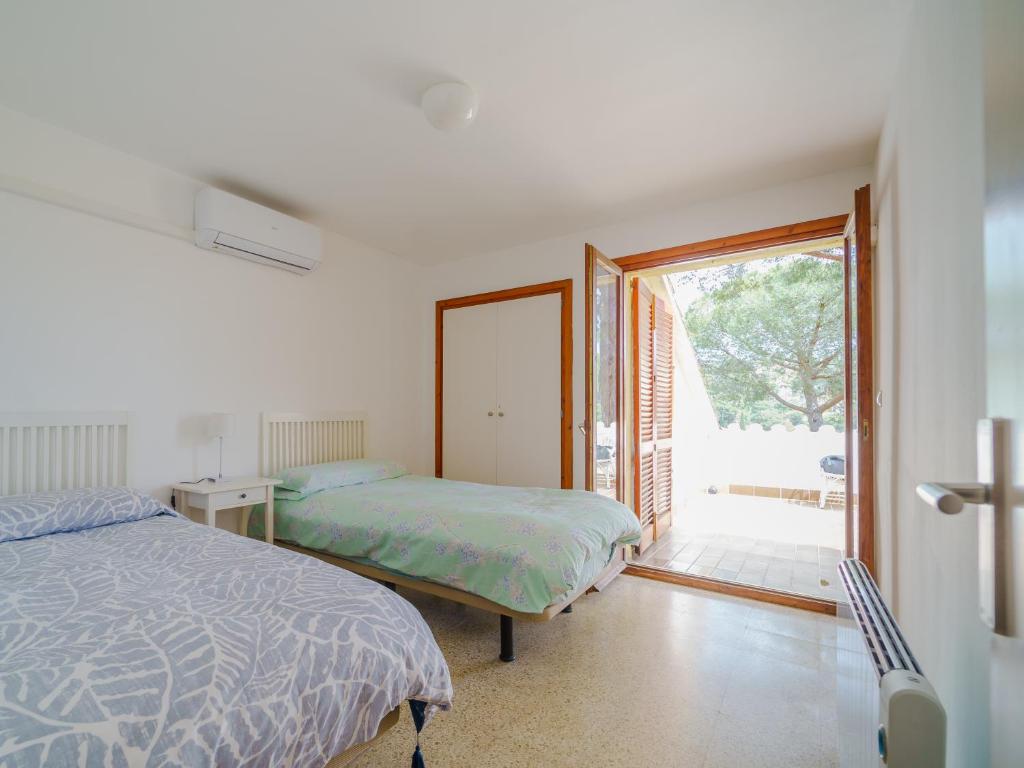 a bedroom with two beds and a sliding glass door at Villa in Tossa de Mar (Santa María de Llorell) in Tossa de Mar