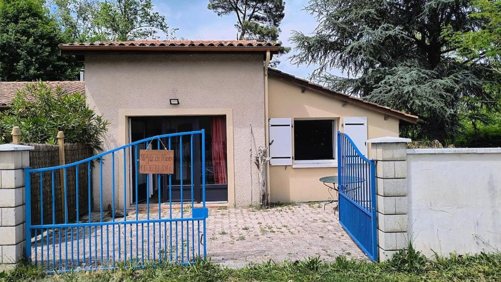 un cancello blu di fronte a una casa di Le Gîte du Lac d'Hostens a Hostens