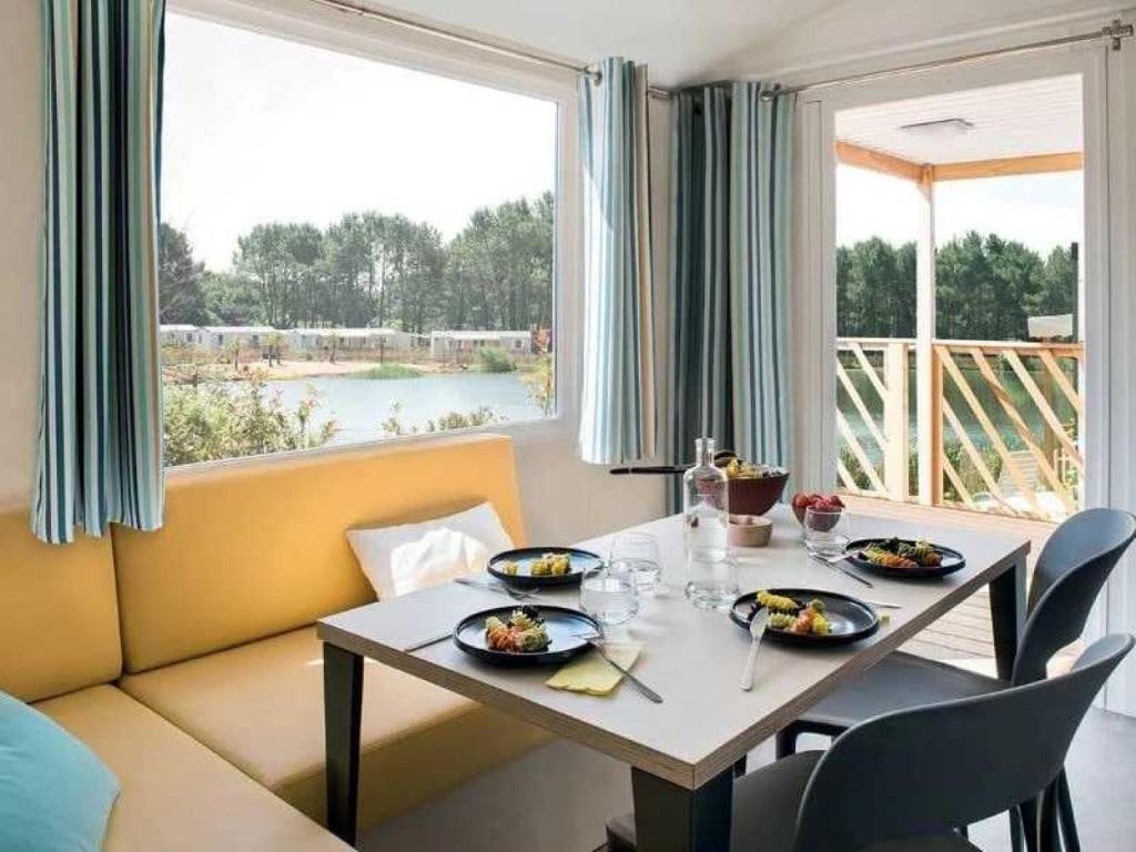 une salle à manger avec une table et une grande fenêtre dans l'établissement Camping 3 étoiles - Parc aquatique - eehagb, à Châtelaillon-Plage