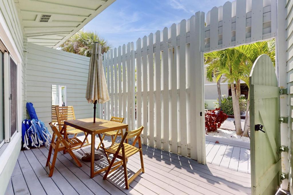a porch with a table and chairs and a fence at 53 Steps to Beach in Clearwater Beach