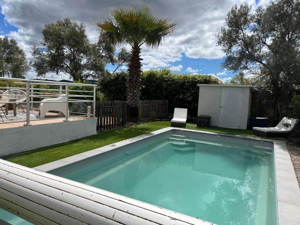 a swimming pool in a yard with a palm tree at Villa au calme avec piscine in Saint-Jean-de-Fos
