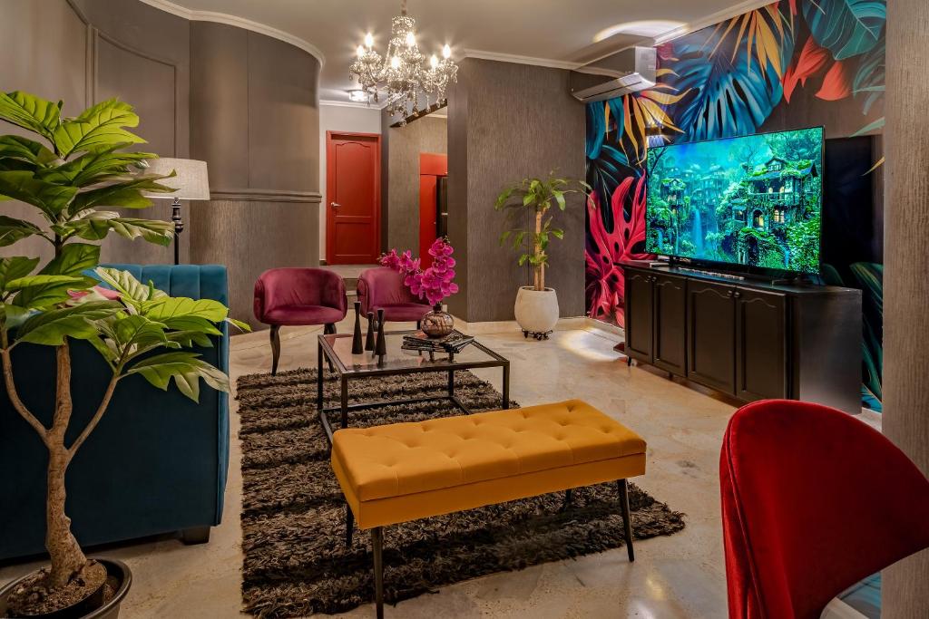 a living room with a large screen tv and plants at Apartamento Tropical Gótico in Cali