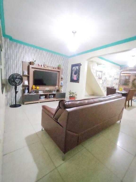 a living room with a couch and a flat screen tv at Casa para COP30 no Centro de Belém in Belém
