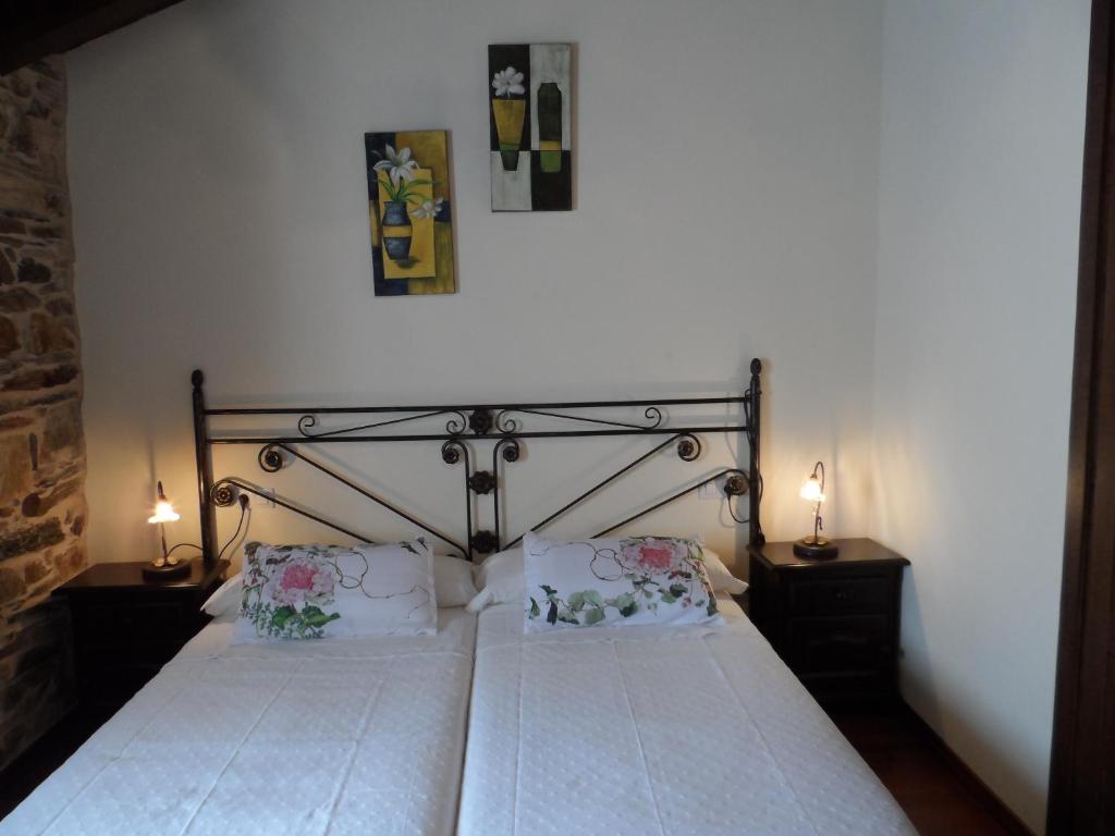 1 dormitorio con 1 cama grande y 2 lámparas en ambos lados en A Cantina, en Mouromorto