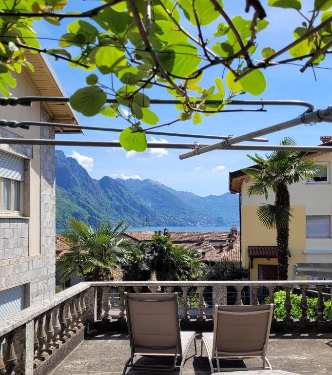 a balcony with chairs and a view of the mountains at Lake Soft Blue Mountain Lake Iseo Hospitality in Riva di Solto