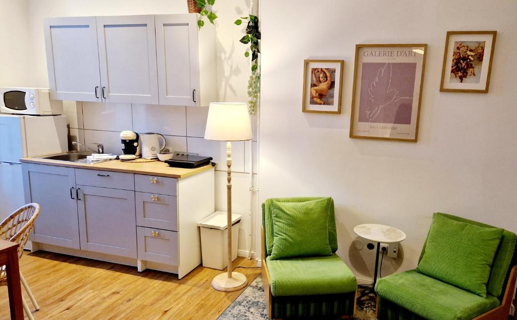 eine Küche mit 2 grünen Stühlen und einem Tisch in der Unterkunft Stylish & Cosy Apartment in Berlin, WiFi in Berlin