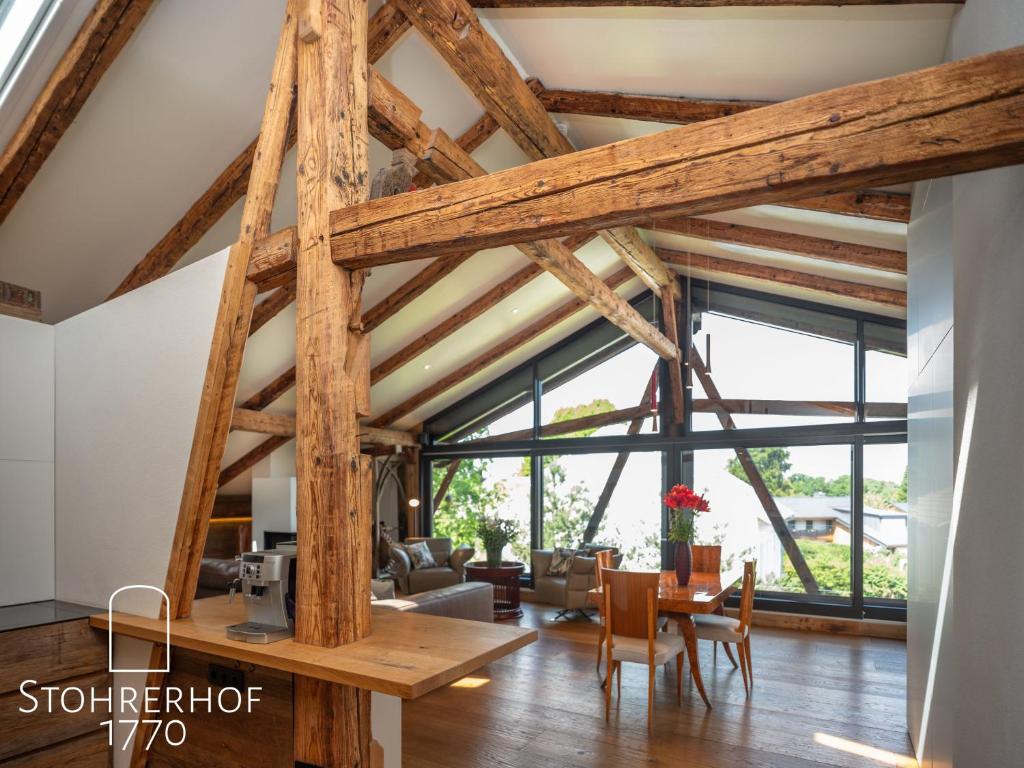 a room with wooden beams and a table and chairs at Appartement In Riederau Mit Terrasse Und Garten in Dießen am Ammersee