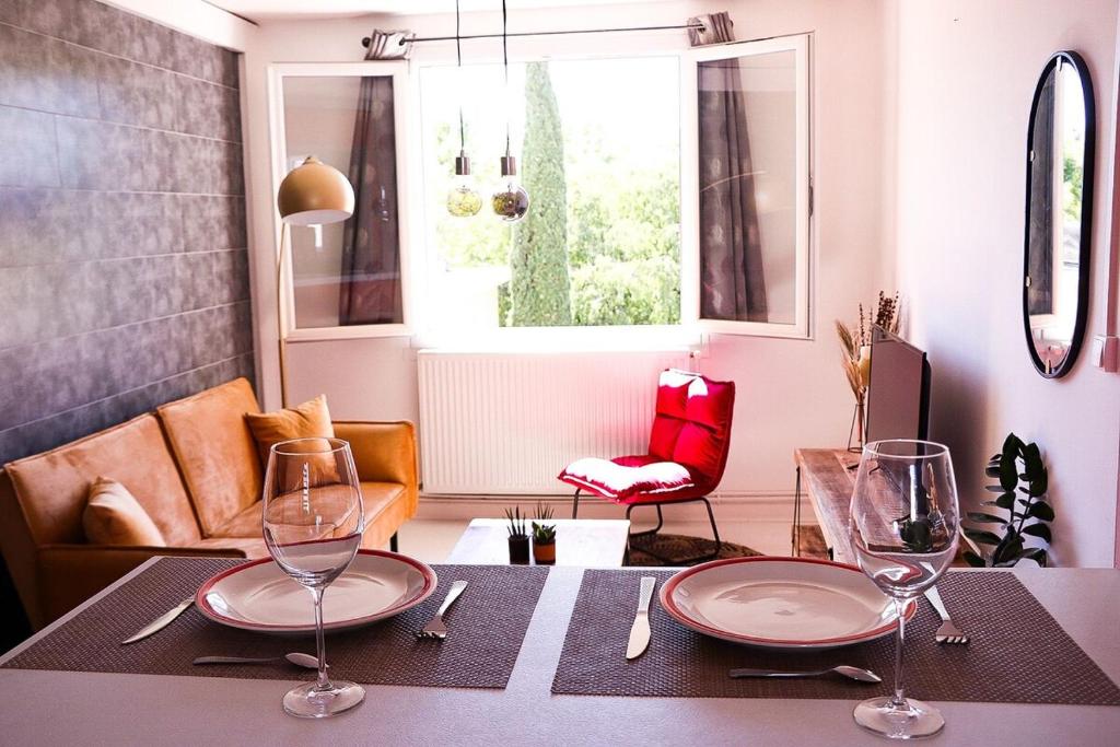 a table with two wine glasses on top of it at Le Luz Charmant T3 in Valence