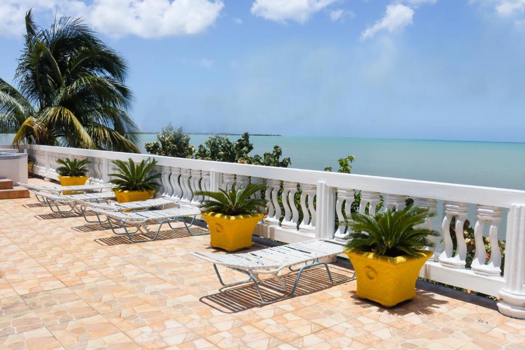 a row of chairs and plants on a balcony at Oceanfront Family Villa in Black River