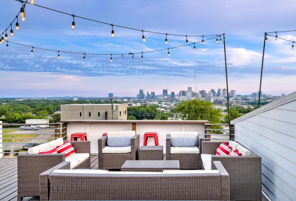 a patio with wicker furniture and lights on a roof at The Pardi House by Stay Local Nashville in Nashville