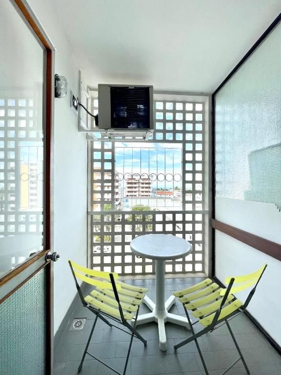 a balcony with a table and two chairs and a tv at Appartamento Celeste I RelaxLagoonView in Lignano Sabbiadoro
