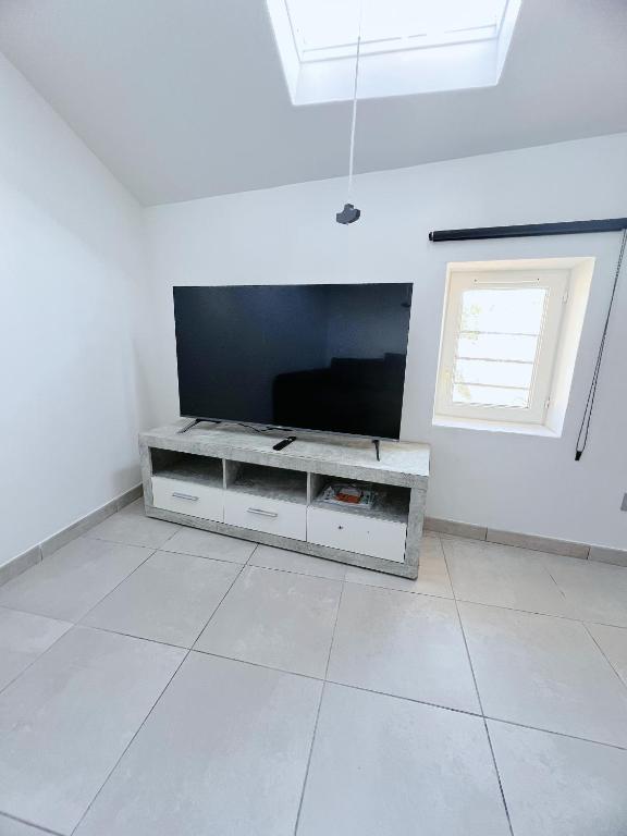 un salon avec une grande télévision à écran plat dans l'établissement Sous les toits du centre-ville, à Narbonne