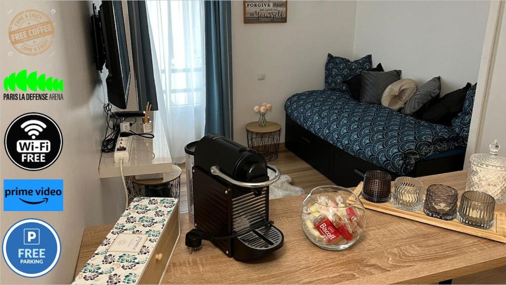 a small living room with a bed and a table at Charming studio in La Défense with free parking in Courbevoie