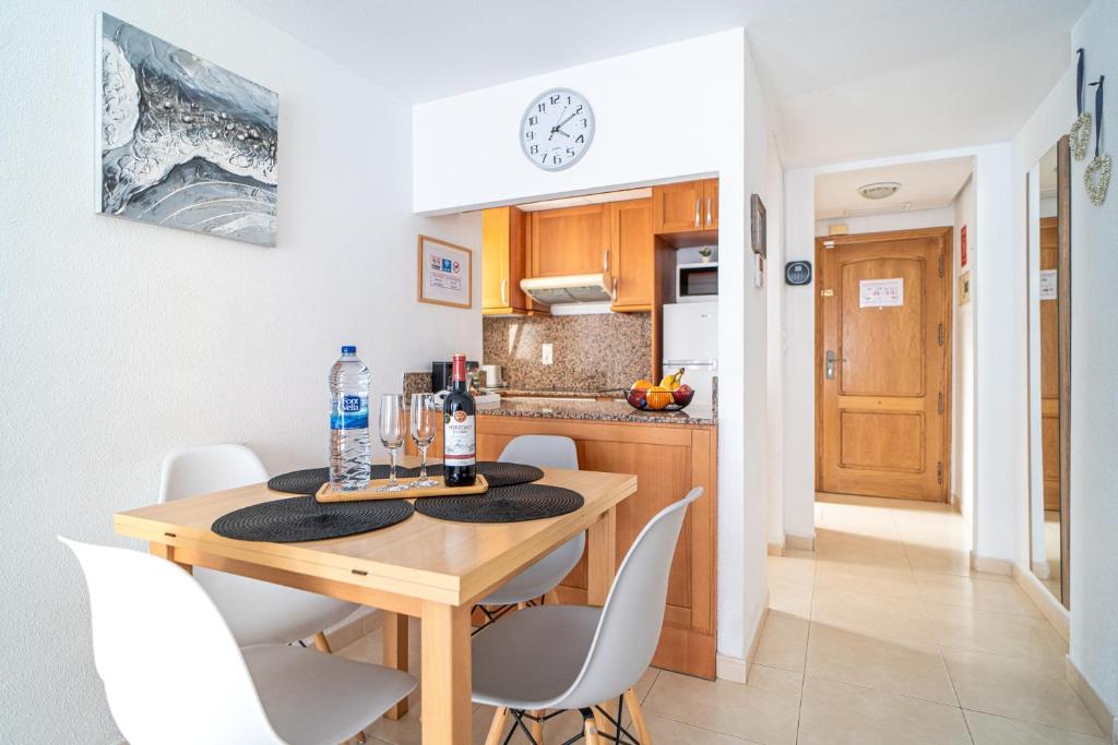 kuchnia i jadalnia z drewnianym stołem i krzesłami w obiekcie Apartment Los Locos Torrevieja Costa Blanca w mieście Torrevieja