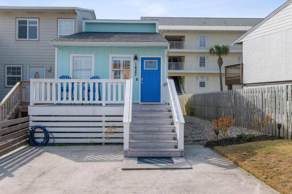 a small house with a blue door and stairs at Sandy Paws in Navarre