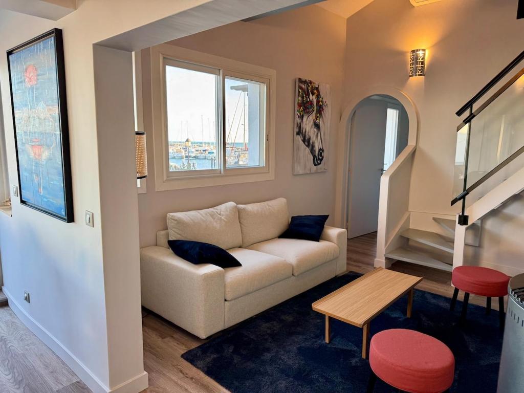 un salon avec un canapé et une table dans l'établissement Vue Mer Climatisé - 11 pers, à Saintes-Maries-de-la-Mer
