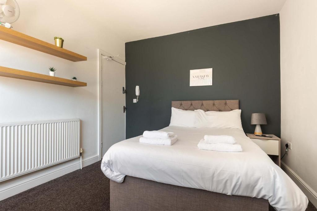 a bedroom with a large bed with two towels on it at Peaceful Room in Doncaster Shared House w Kitchen in Doncaster