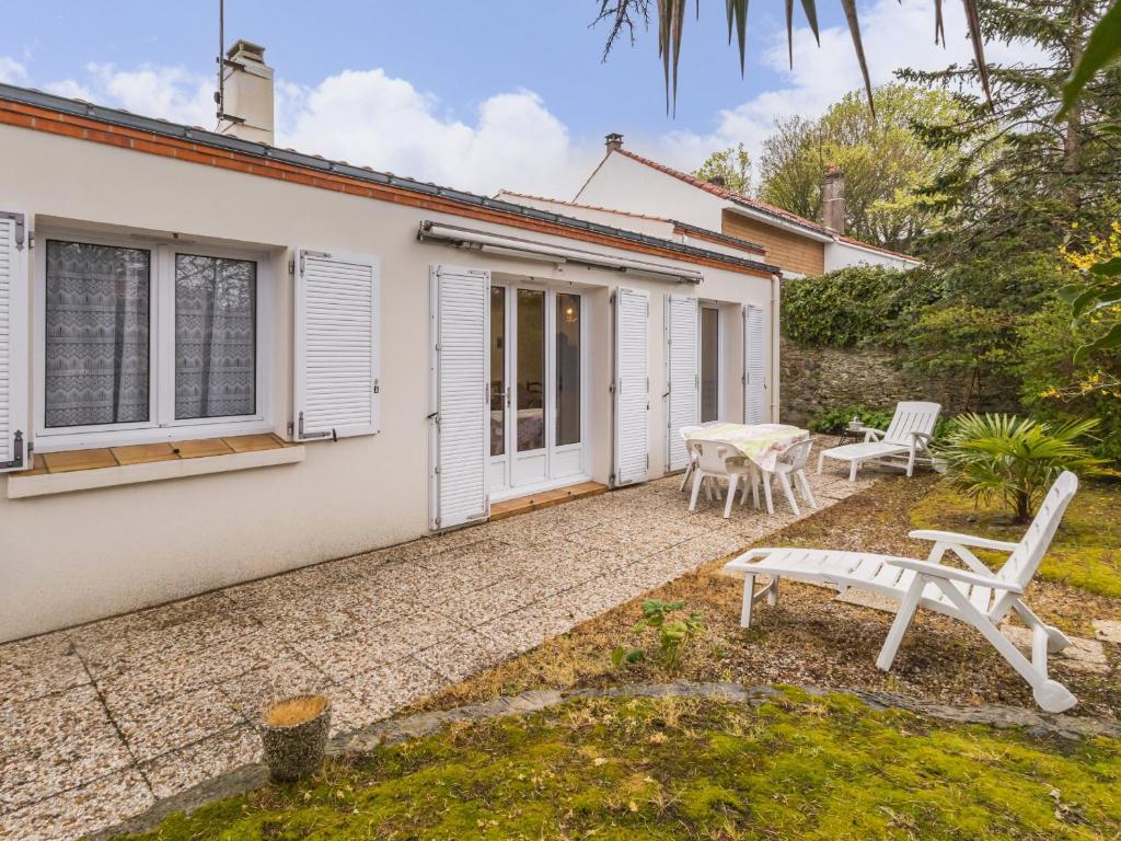 Cette maison blanche dispose d'une terrasse, d'une table et de chaises. dans l'établissement Maison indépendante à Pornic, proche vieux port et plage - FR-1-306-1307, à Pornic