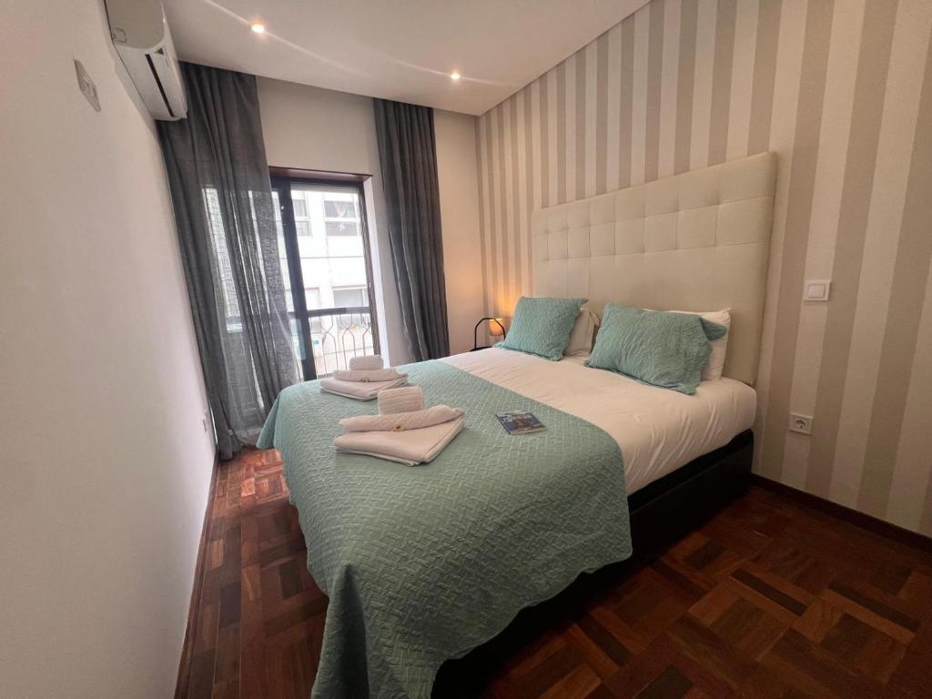a small bedroom with a bed with towels on it at OPORTO APARTMENT LUXURY in Porto