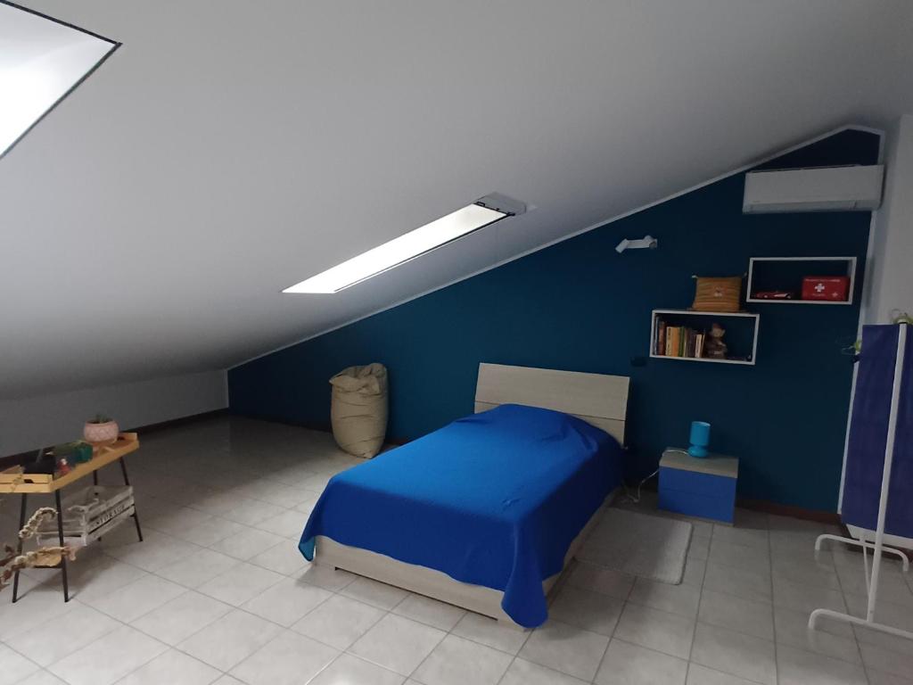 a blue bedroom with a bed and a table at Casa Margherita in Tribiano