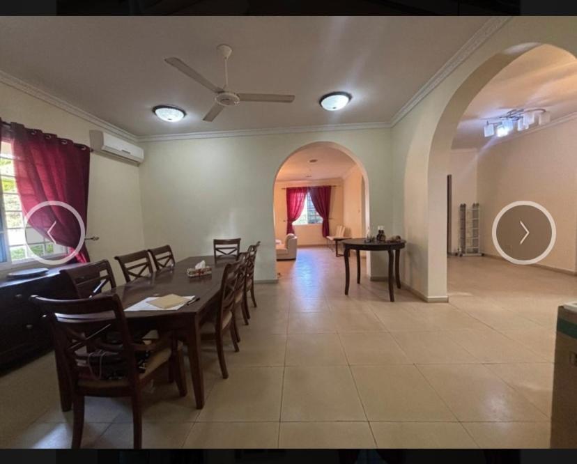 a dining room with a table and chairs and a living room at Villa Zara in Zanzibar City