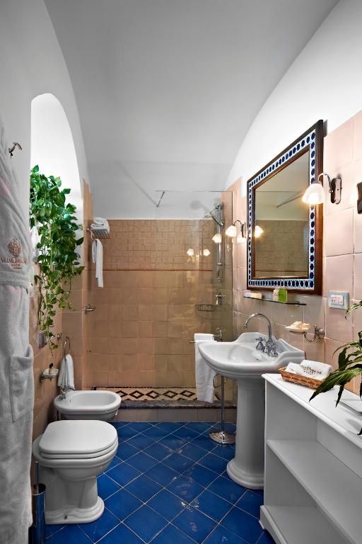 a bathroom with a toilet and a sink and a mirror at Hotel Villa Cimbrone in Ravello