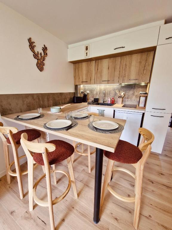 une cuisine avec une table et des chaises en bois dans l'établissement Studio Hart 2, aux Gets