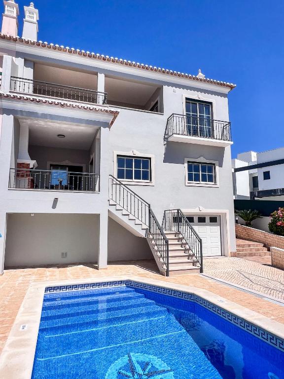 a villa with a swimming pool in front of a house at Silver Globe in Albufeira