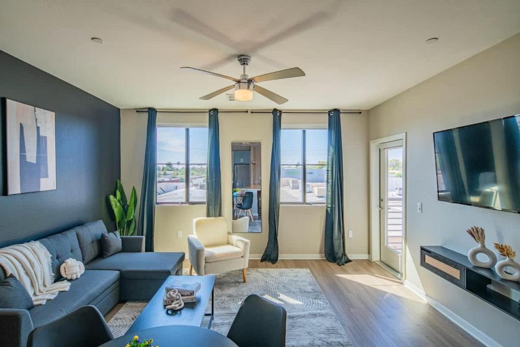 uma sala de estar com um sofá azul e uma TV em Convenient 1BR Uptown Biltmore Gym Pool Parking em Phoenix