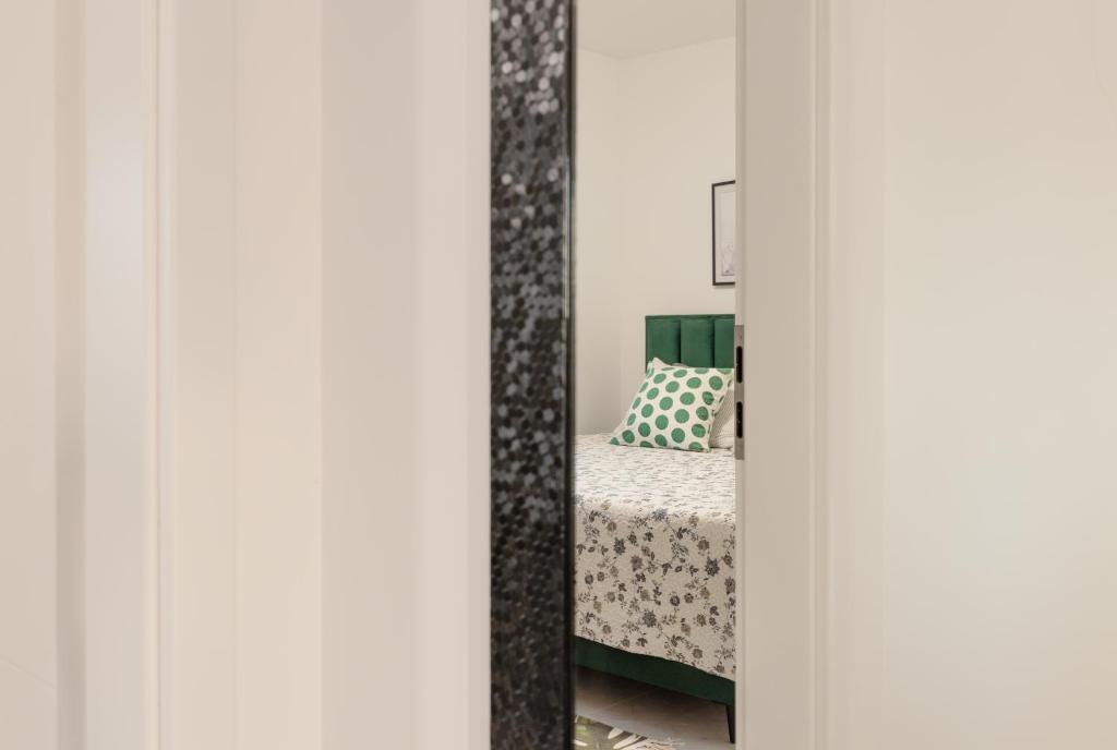 a bedroom with a bed and a mirror at Apartmani Sofija in Bibinje