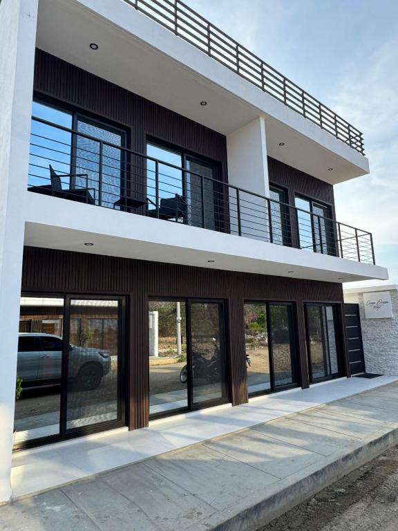 a building with glass doors and a balcony at Ocean Dream Apartment E2-A4 in San Juan del Sur