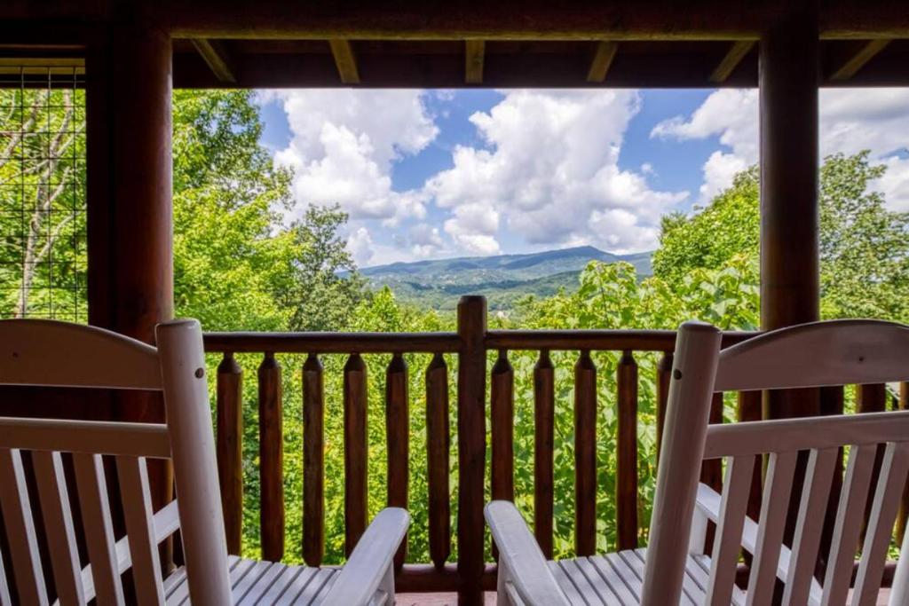two chairs on a porch with a view of the mountains at Mountain Sunrise by Avada Properties in Sevierville