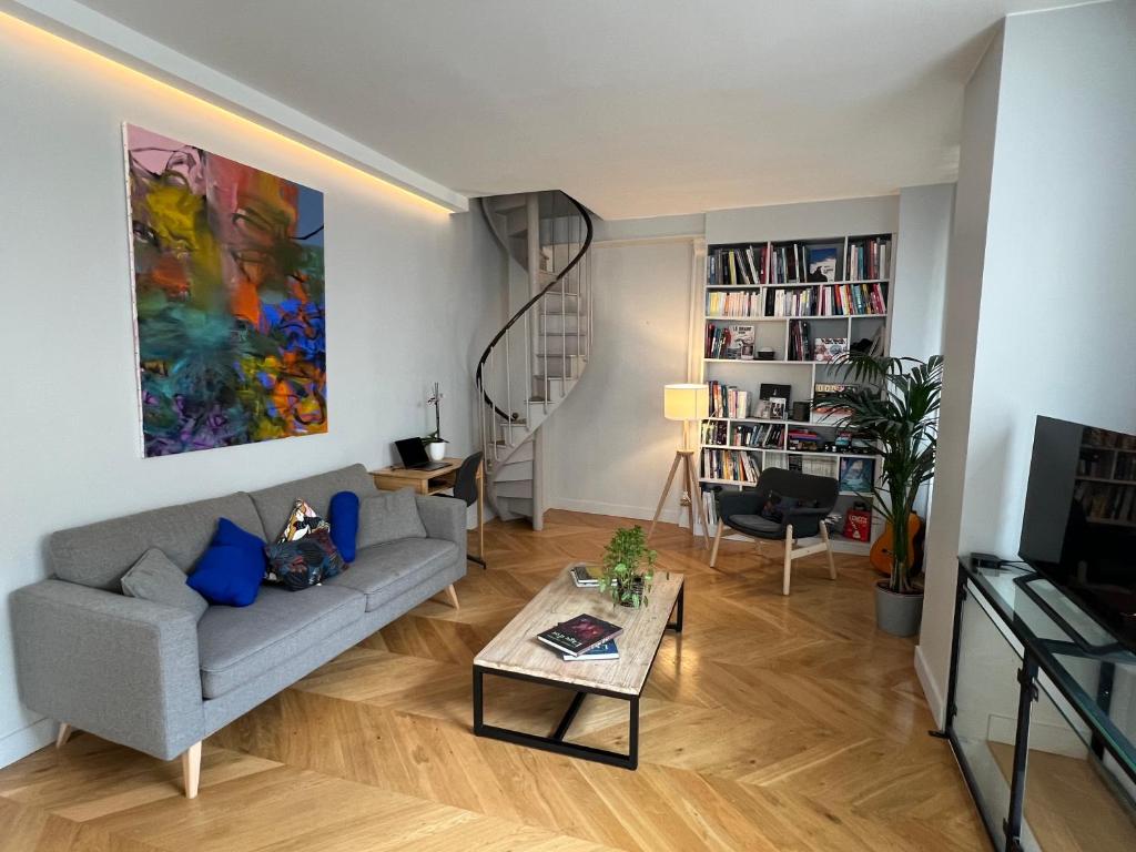 un salon avec un canapé et une table dans l'établissement Ancienne Boulangerie entièrement rénovée 5 Chambres 3 min métro 4 Barbara, à Montrouge