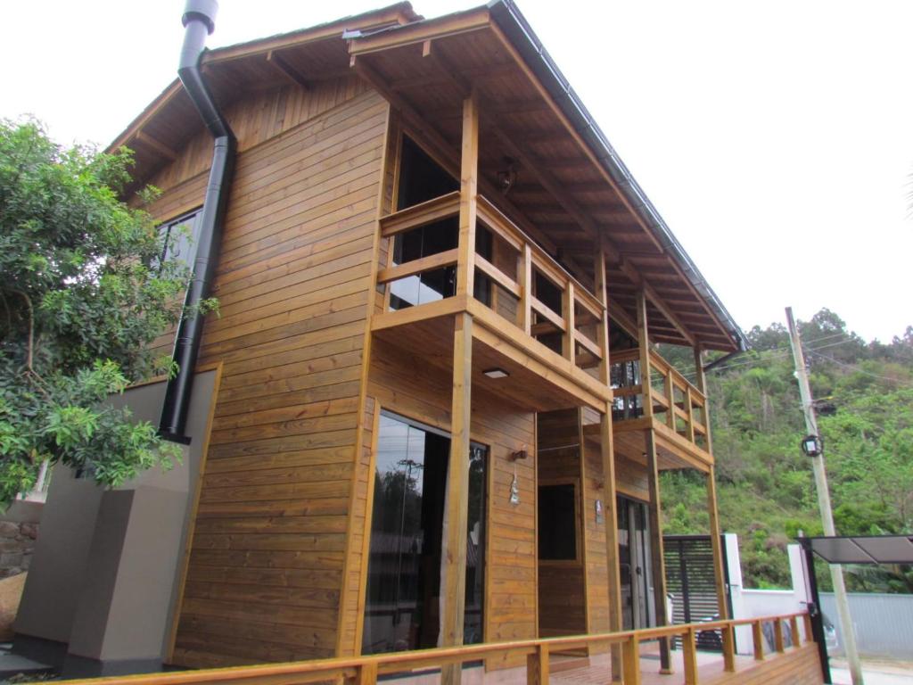 una casa in legno con una grande finestra su una terrazza di Cabanas LUPE Pedro a Governador Celso Ramos