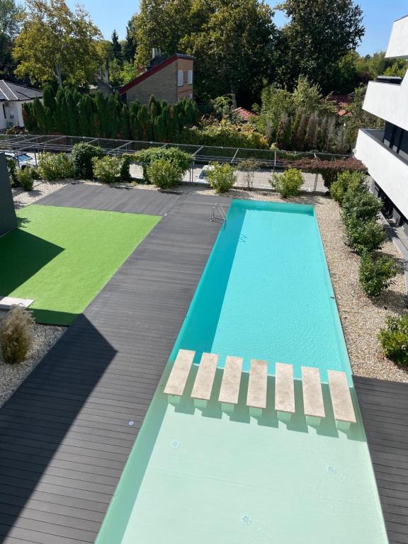 une piscine au milieu d'un jardin dans l'établissement Lake and Pool Apartman Balatonszemes, à Balatonszemes