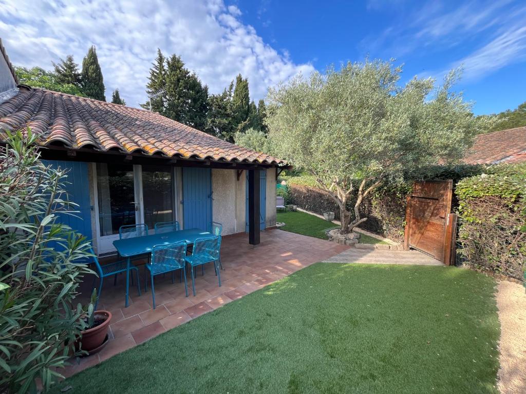 d'une terrasse avec une table bleue et des chaises dans la cour. dans l'établissement Maison provençale, à Eyguières