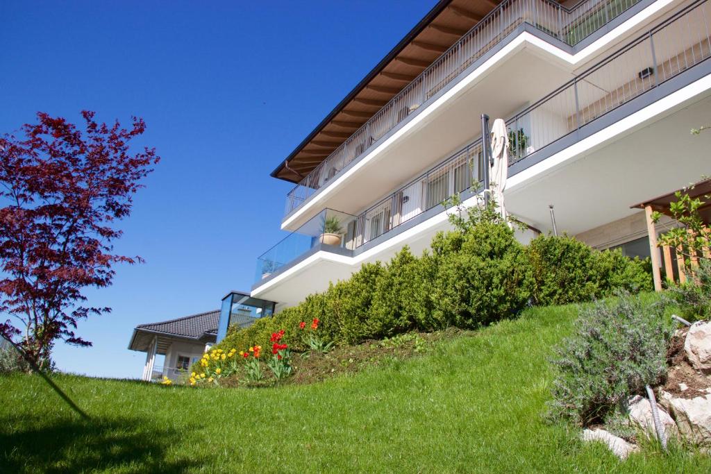 a house on a grassy hill with flowers at Apartments Villa Traunseeblick in Gmunden