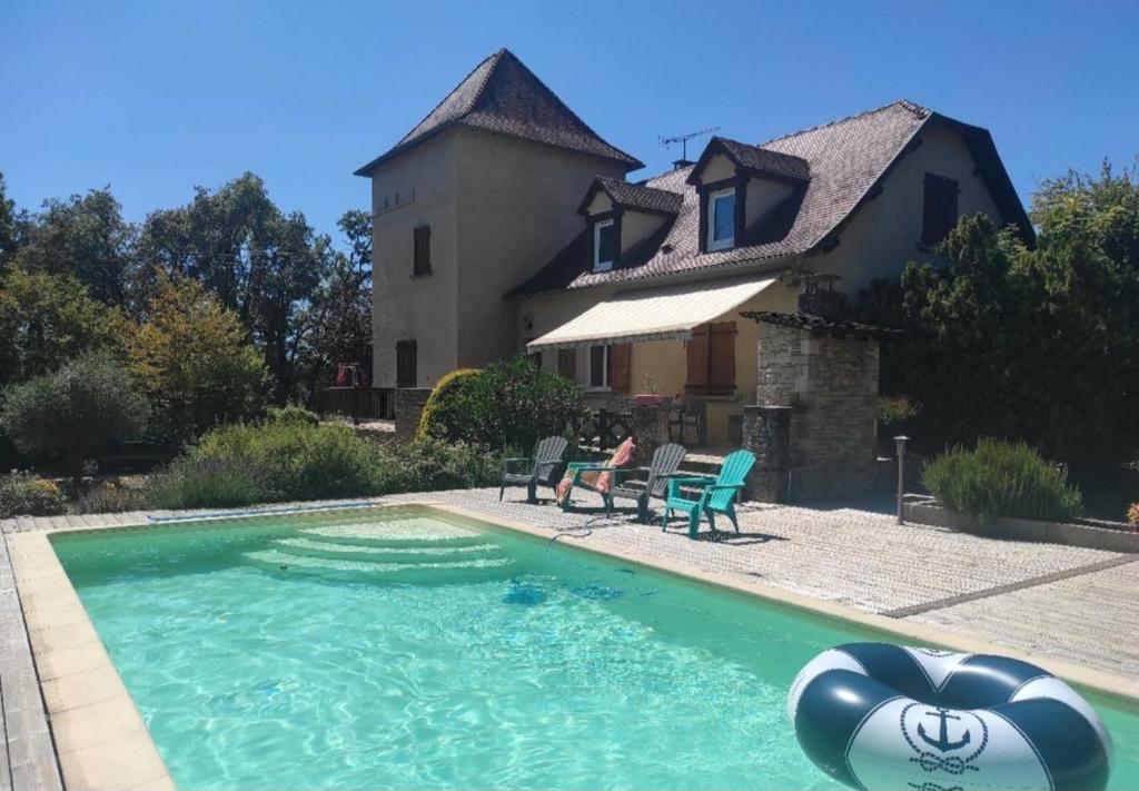 une maison avec une piscine devant une maison dans l'établissement Maison de vacance avec piscine, à Villeneuve-dʼAveyron