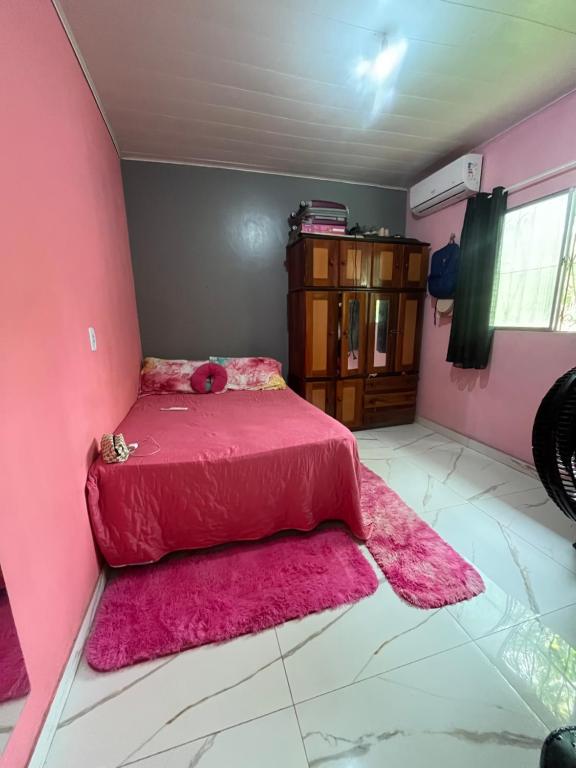 ein rosa Schlafzimmer mit einem rosa Bett mit einer rosa Decke in der Unterkunft Casa na ilha do combu in Acará