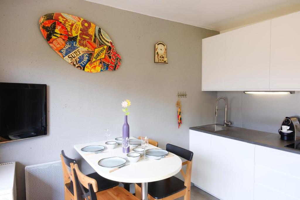 une cuisine avec une table blanche, des chaises et un vase dans l'établissement Beautiful studio with balcony - near beach, à Sainte-Maxime