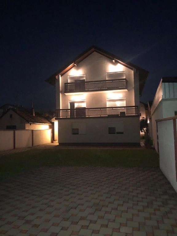 a large house with lights on the side of it at night at Ema's apartments in Bihać